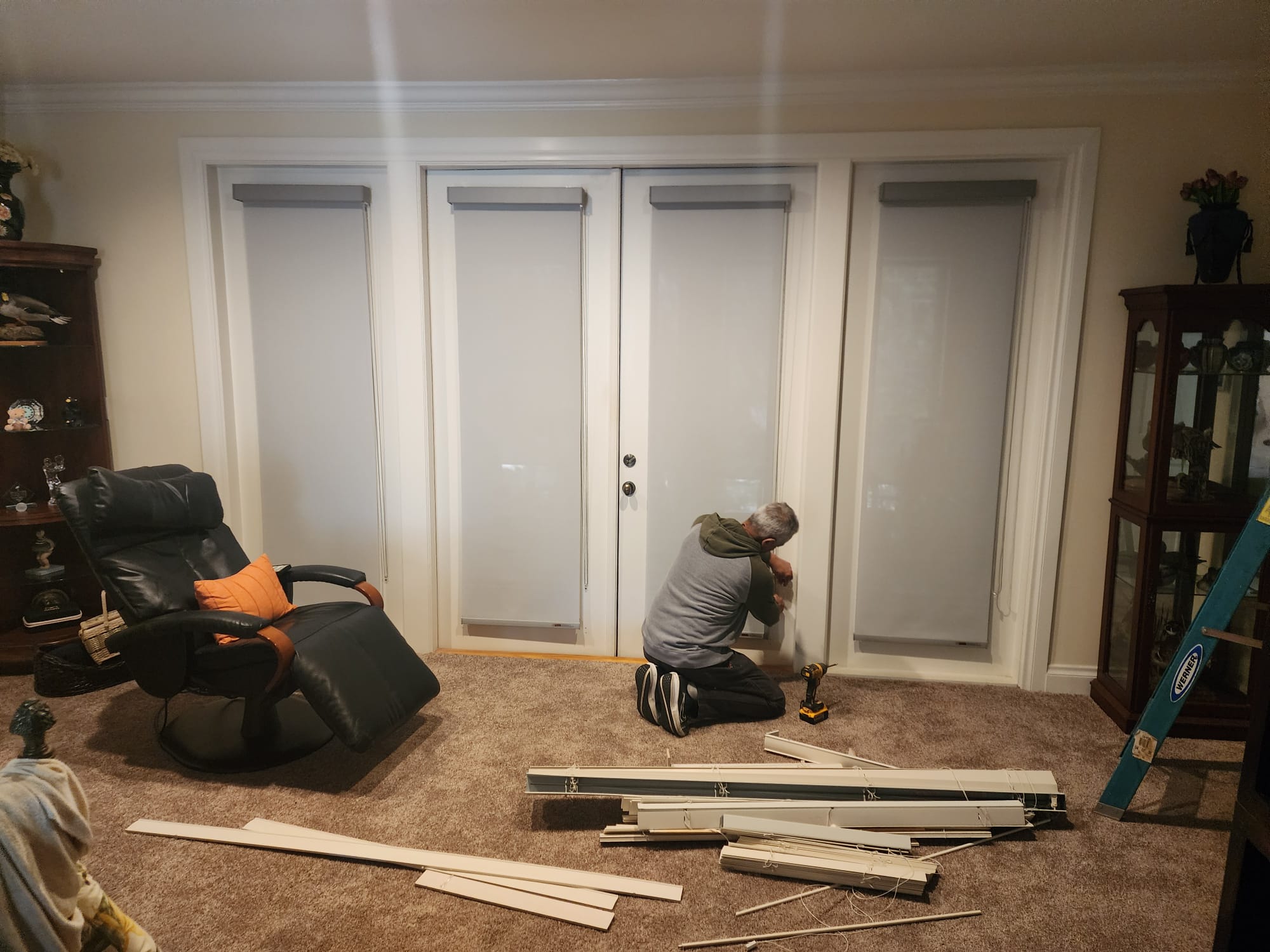 Installer mounting roller shades on french doors